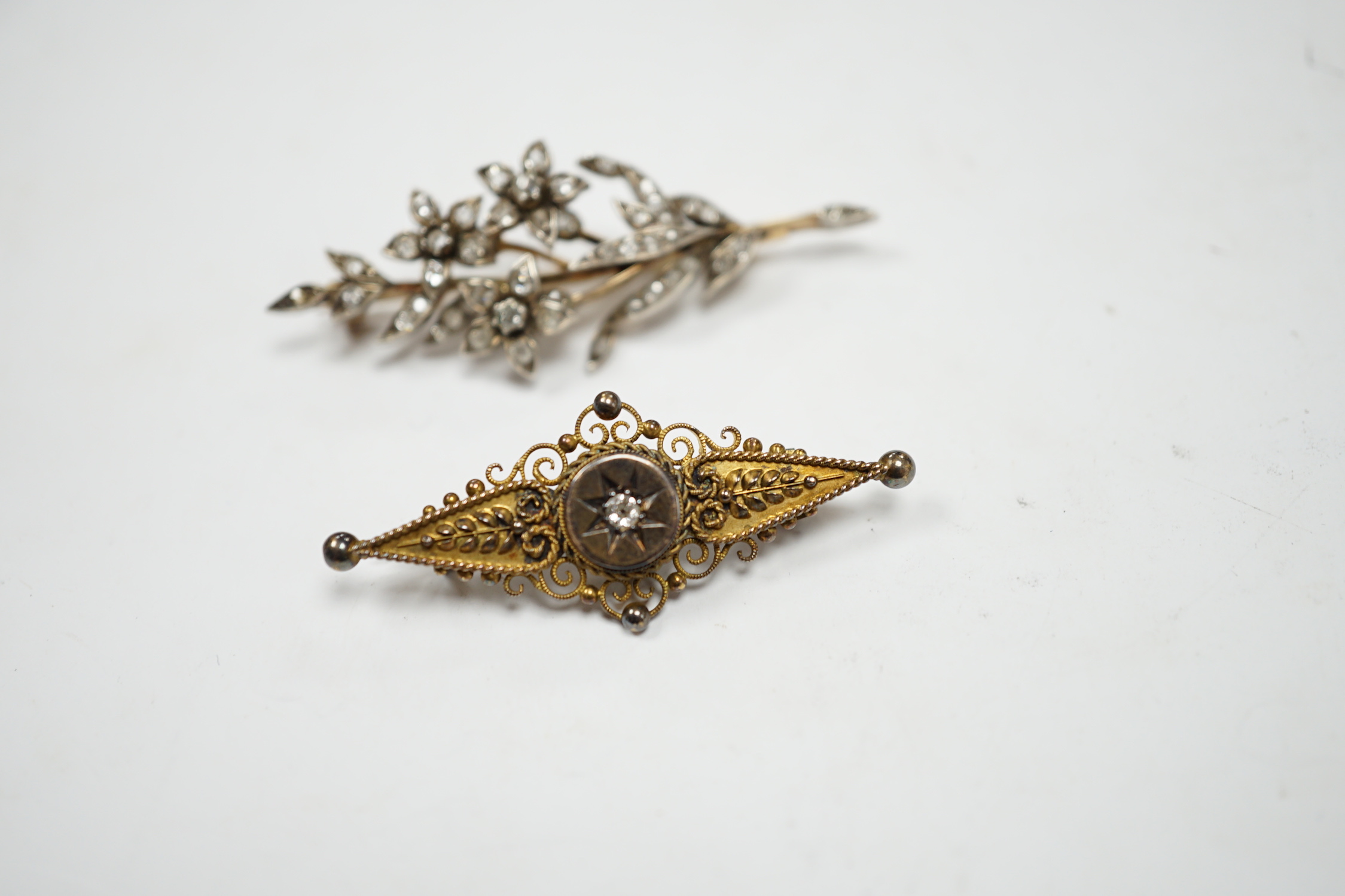 A late Victorian, yellow metal, white metal and diamond cluster set foliate spray brooch, 53mm, together with a Victorian 15ct gold and singe stone diamond set bar brooch, gross weight 11.5 grams.